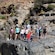 A group of Guests posing with a guide on top of a cliff at El Salto Canyon